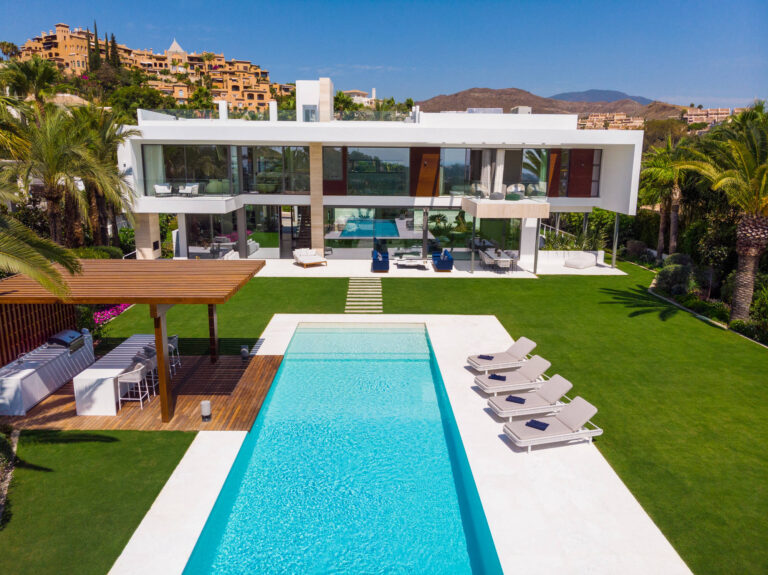 Luxury villa in Marbella with pool and palm trees.